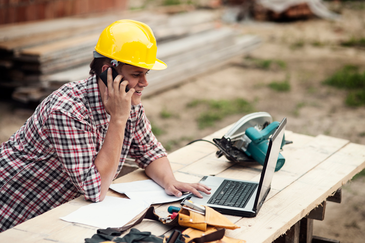 Construction working working on laptop